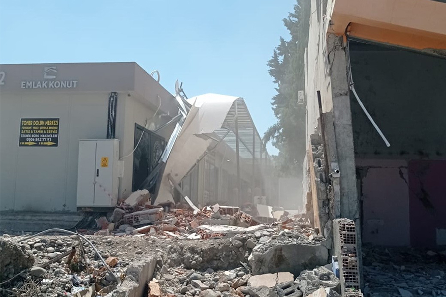 Ağır hasarlı binanın duvarı iş yerinin üzerine yıkıldı