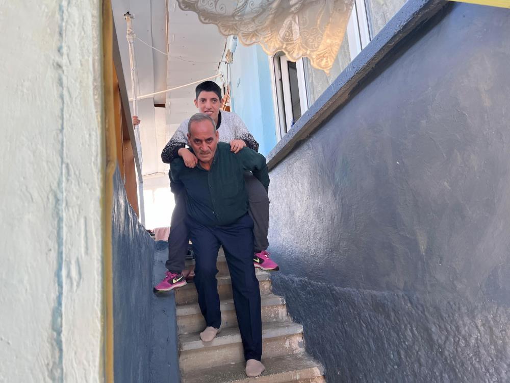 73 yaşındaki baba ayağındaki platine rağmen kızını metrelerce sırtında taşıyor