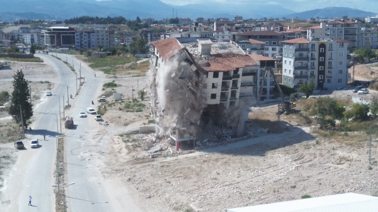 Hatay’ın Antakya ilçesinde 9 katlı binanın iş makinesinin darbesiyle yerle bir olduğu anlar dron kamerasıyla an be an görüntülendi.