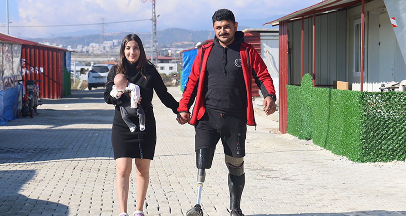 Hatay’da depremde 2 bacağı ampute olan ve protez bacakları sayesinde yeniden yaşama tutunan 21 yaşındaki Emre Yüksek, depremin ardından evlendiği eşinin elini tutarak kucağında evladıyla gezmenin mutluluğunu yaşıyor.