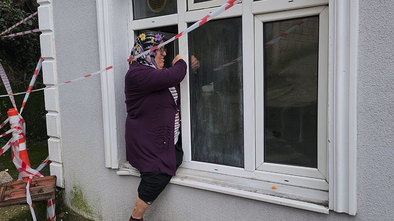 Yaşlı çift, heyelan nedeniyle girişi kapanan evlerine pencereden giriyor