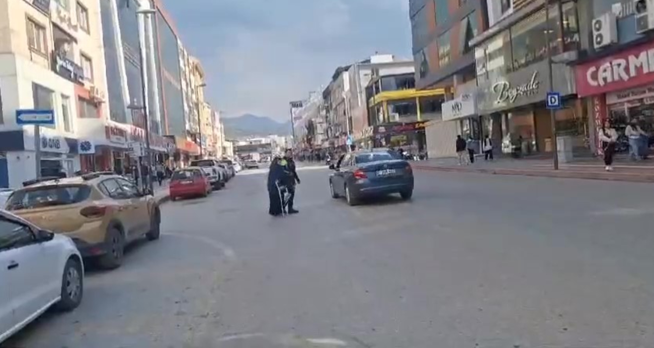 Yolun karşısına geçmek isteyen yaşlı kadına polis yardım etti