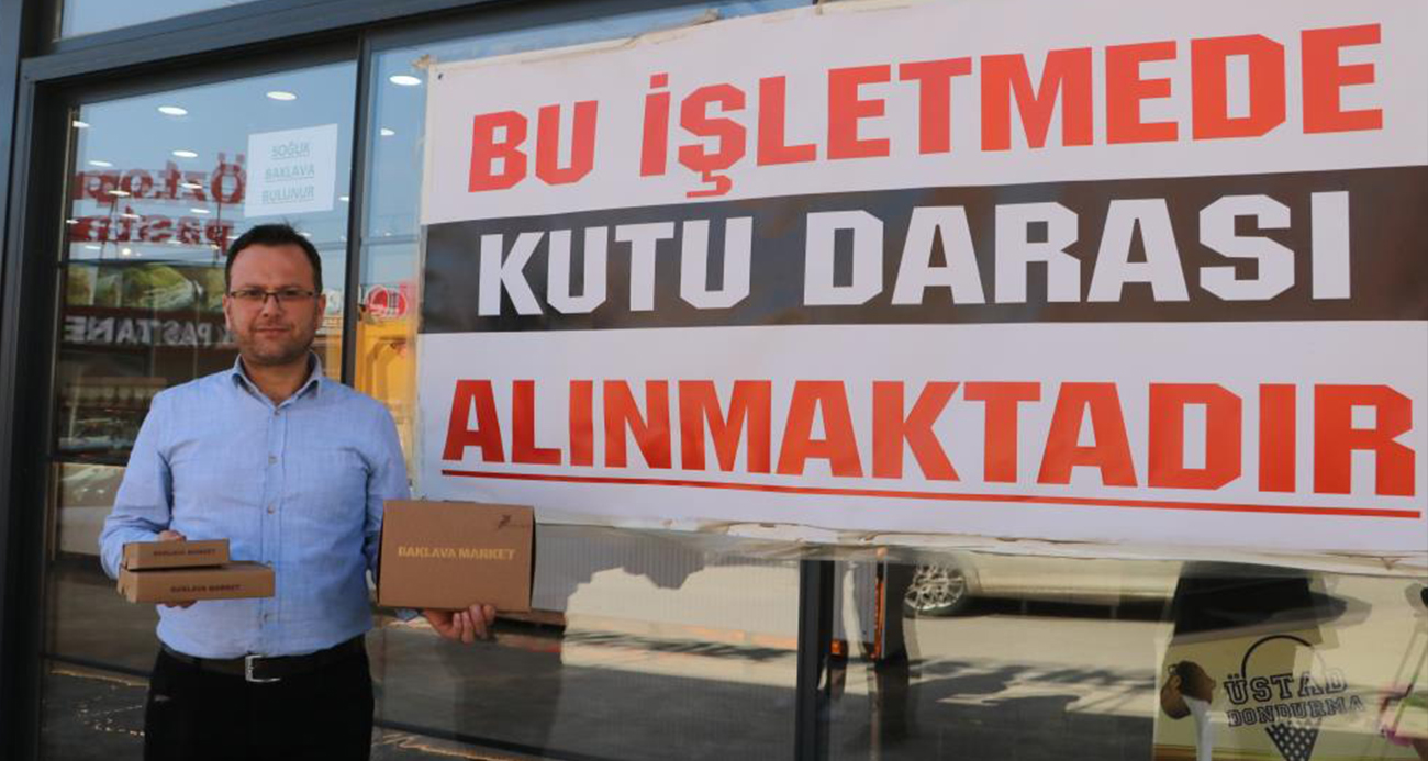 Baklava satışı yapan firma kutu darası tartışmasına 21 şubesine astığı pankartla son verdi