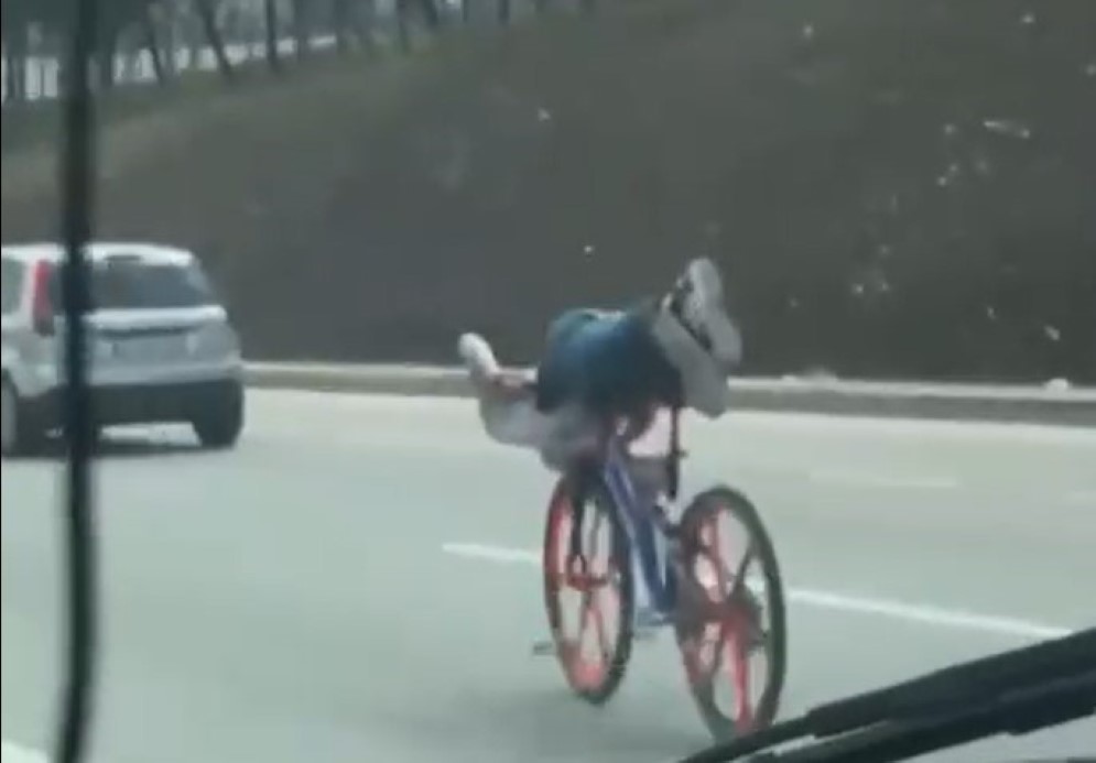 Bisikletin üzerinde uzanarak giden gençler trafiği tehlikeye attı