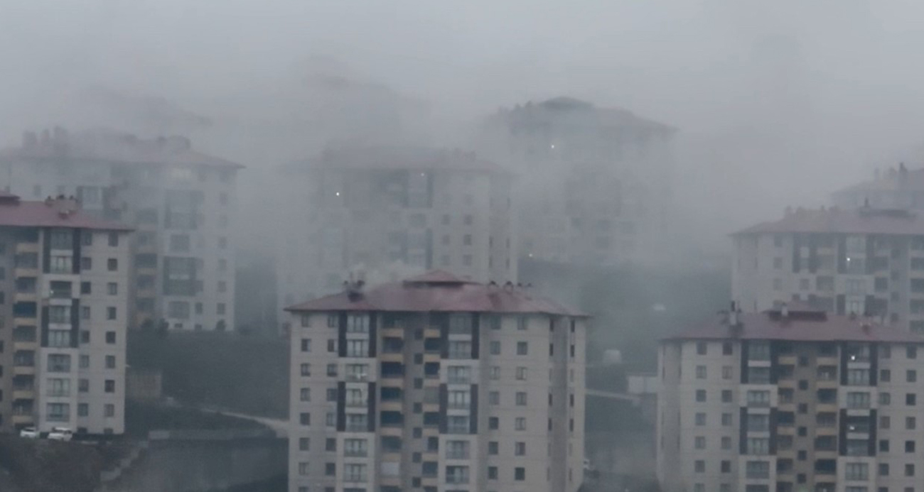 Yüksekova’da binaların üzerini kaplayan yağmur bulutları kamerada