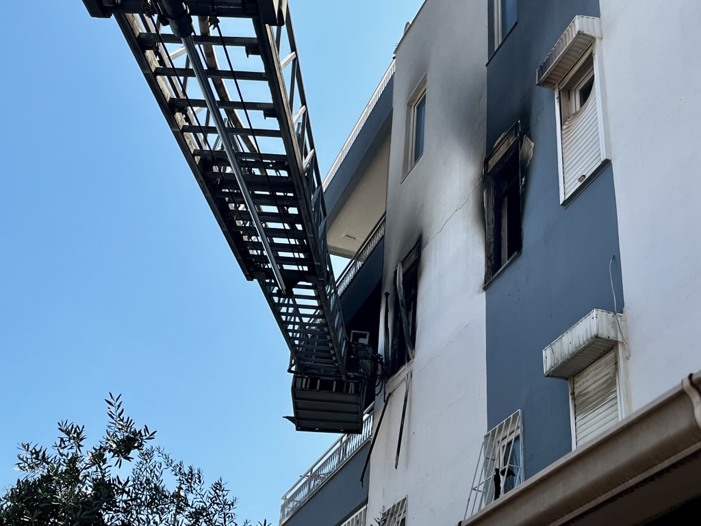 Alevlerin sardığı evde balkona sığındı, kedisini elinden bırakmadı