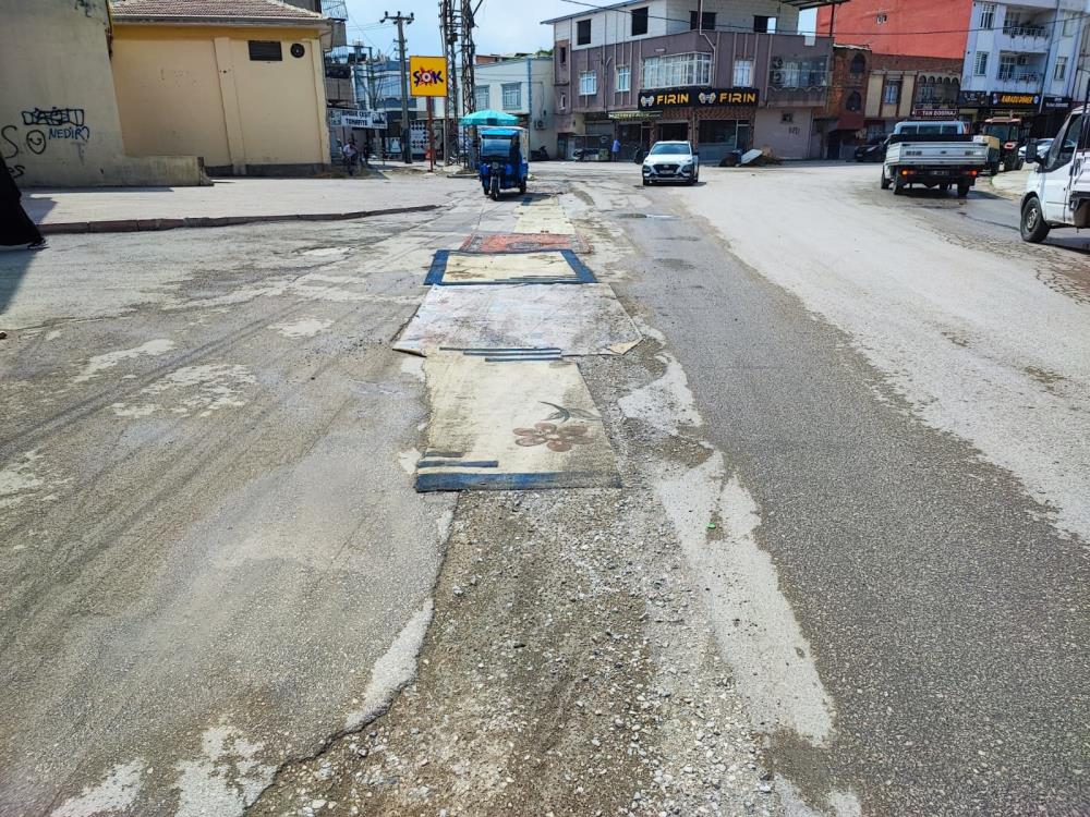 Adana’da belediyenin yapmadığı yola esnaftan ilginç çözüm: Yola asfalt yerine halı serildi