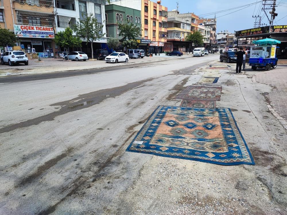 Adana’da belediyenin yapmadığı yola esnaftan ilginç çözüm: Yola asfalt yerine halı serildi