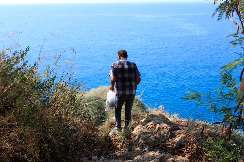 Denize sıfır sarp kayalıklarda ot topluyor, gören itfaiyeyi arıyor