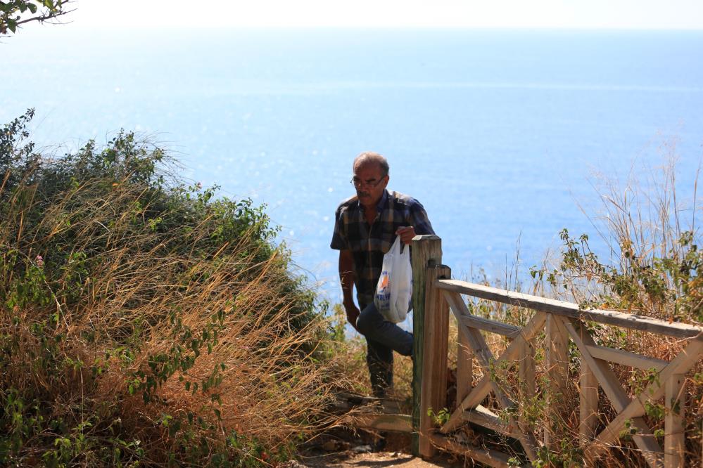 Denize sıfır sarp kayalıklarda ot topluyor, gören itfaiyeyi arıyor