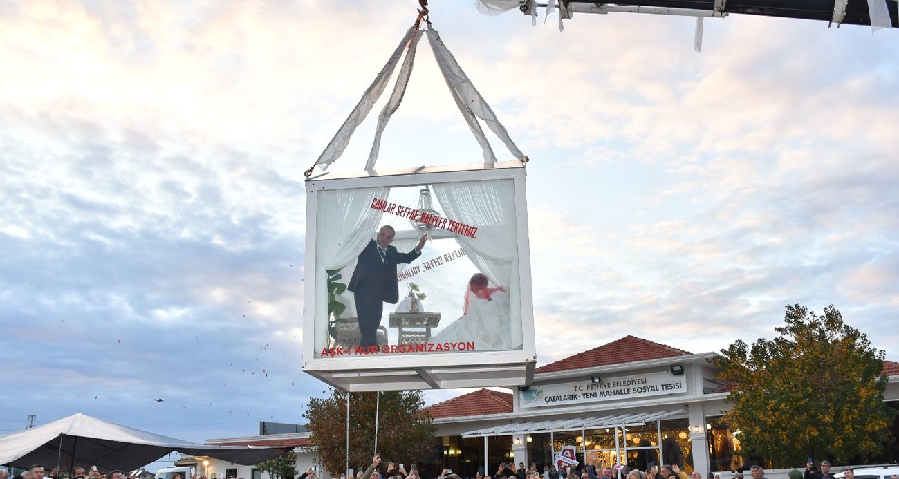 Muğla’nın Fethiye ilçesinde sıra dışı düğün organizasyonunda cam vitrine alınan gelin ve damat, tır ile Fethiye caddelerinde gezdirilirken, daha sonra düğün salonunda vinçle tırdan indirildi.