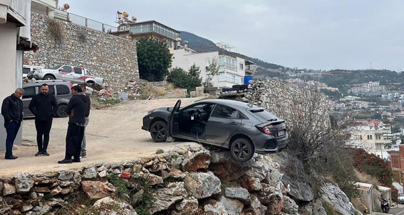 Antalya’da geri manevra yapan araç şarampolde asılı kaldı