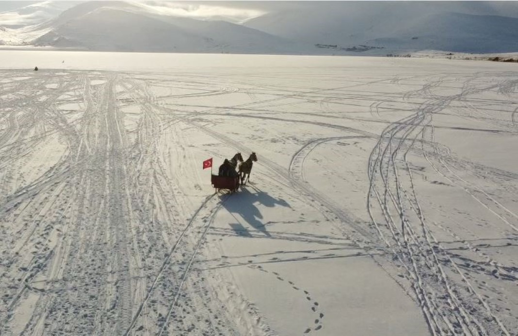 Çıldır Gölü’nün yüzeyi, soğuk havanın etkisiyle buz tutmaya başladı. En düşük hava sıcaklığının sıfırın altında 20’lere kadar düştüğü bölgede yüzeyi buzla kaplanan gölde atlı kızak seferleri de önceki yıllara oranla geç de olsa başladı.