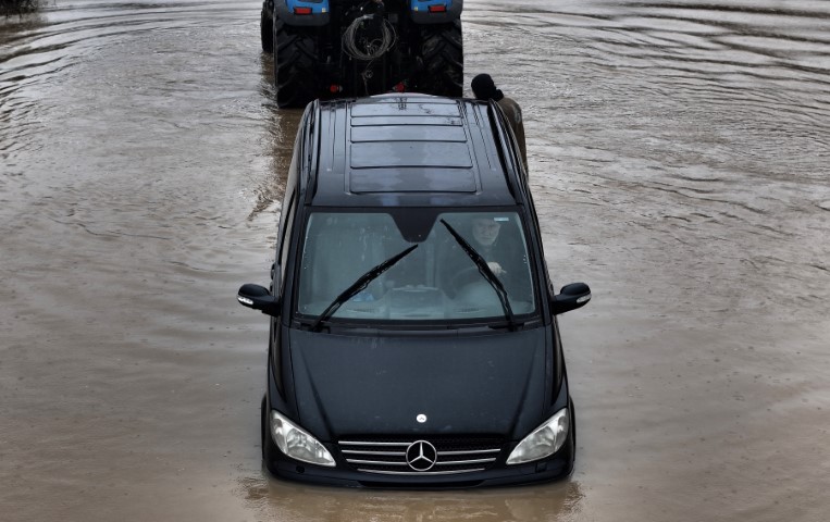Göle dönen yolda mahsur kalan sürücü aracını bırakmadı, kurtarma anları görüntülendi
