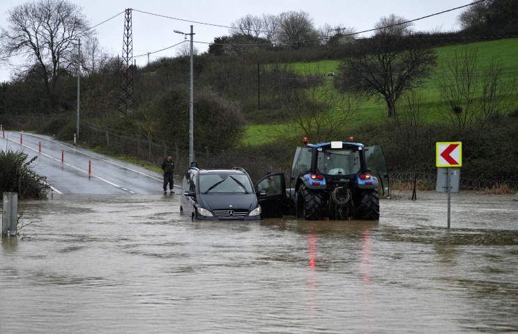 Göle dönen yolda mahsur kalan sürücü aracını bırakmadı, kurtarma anları görüntülendi