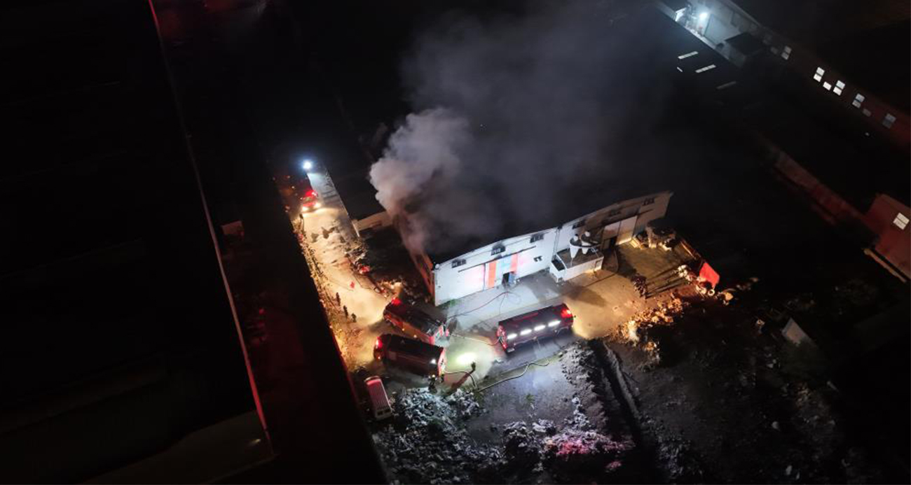 Kayseri Organize Sanayi Bölgesi'nde (OSB) bir sünger fabrikasında çıkan yangın, ekiplerin müdahalesiyle diğer hangarlara sıçramadan 1 saatte kontrol altına alındı. Yangın anı dron ile havadan görüntülenirken, soğutma çalışmaları sürüyor.