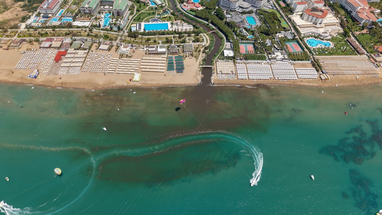 Antalya’nın Manavgat ilçesinin turizminde önemli merkezlerinden olan Evrenseki Sahili, Gömeçli Deresi’nden geldiği ileri sürülen atık sular nedeniyle kahverengiye büründü. Manavgat Kaymakamı Adil Karataş, gerekli tespitlerin yapıldığını, tespitlerin ardından gerekli işlemlerin yapılacağını dile getirdi. Sahildeki manzara dron ile görüntülendi.