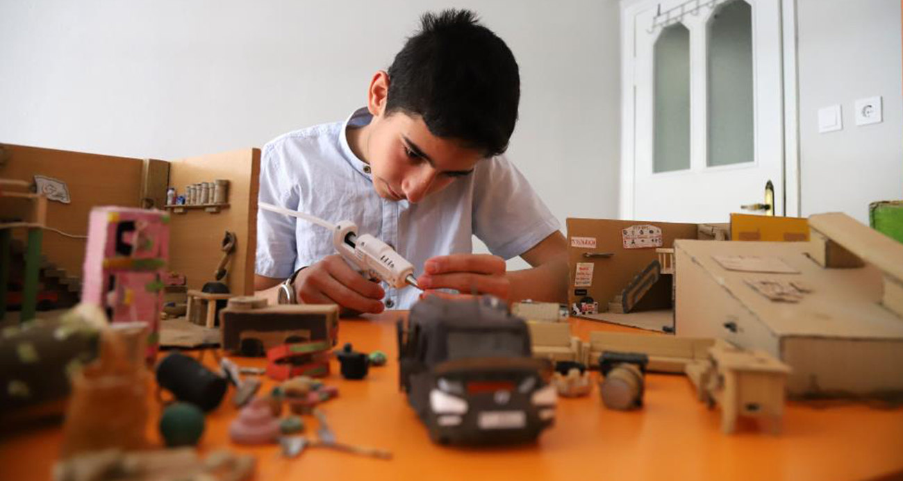 Gümüşhane'de yaşayan 14 yaşındaki Gökay Baran Berker, 8 yaşından beri evdeki atık malzemeleri ve geri dönüşüm ürünlerini göz alıcı minyatür eşyalara dönüştürüyor. Yumurta kutularından tabak, pil demirlerinden inşaat aletleri ve kartonlardan mukavva arabalar üreten genç yetenek, eserleri evinin balkonuna sığmayınca köyünde 10 metrekarelik özel bir hobi evi inşa etti.