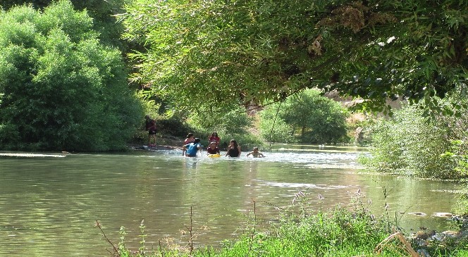 Aşırı sıcaklarda kıyafetleri ile çaya girerek serinliyorlar