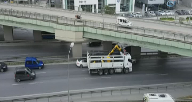 İş makinesi taşıyan kamyon köprüye takıldı