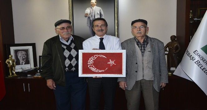 Oğlunun özel olarak yaptığı el işlemesi Türk Bayrağı’nı Başkan Ataç’a hediye etti