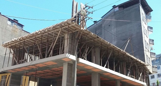 Elektrik direği kaldırılmayınca direği binanın köşesinden geçirdi