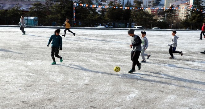 Öğrencilerin buzlu zeminde futbol keyfi