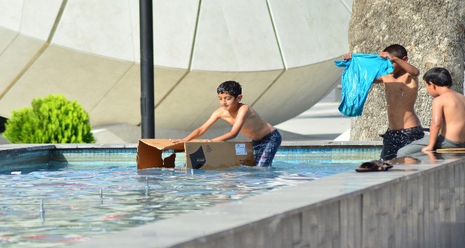 Sıcaktan bunalan çocuklar süs havuzunda serinledi