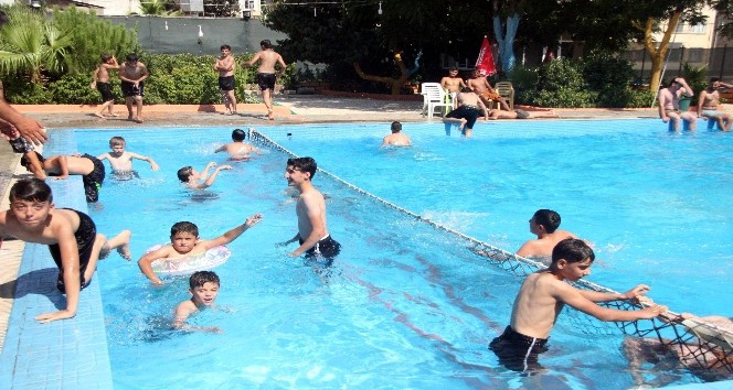 Gençler havuzda yüzerek serinliyor