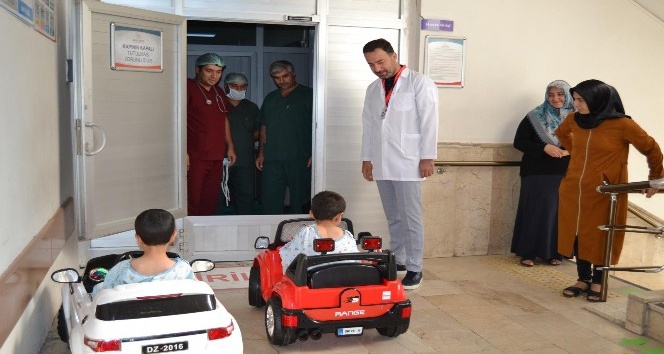 Çocuklar gülerek bindikleri akülü arabayla ameliyata giriyor