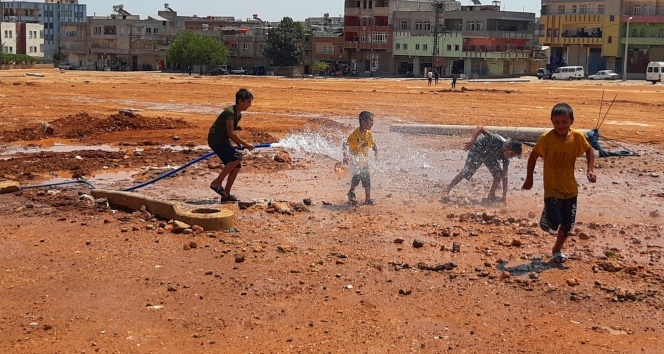 Sıcaktan bunalan çocuklar çamurda halay çekip hortumla serinledi