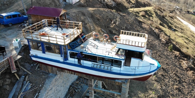 Düzköy ilçesinde beton yapının üzerine yerleştirilen 15 metrelik tekne görenleri şaşırtıyor