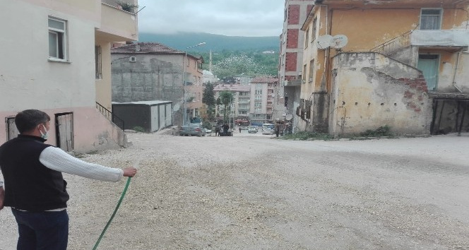 Tozdan bunalan esnaf, çareyi yolu sulamakta buldu