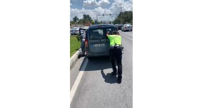 Trafik polisi, yolda kalan aracı iterek sürücüye yardım etti