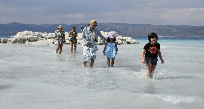 Suyu çekilen Salda gölü kıyısına yakın adaya yürüyerek geçiyorlar