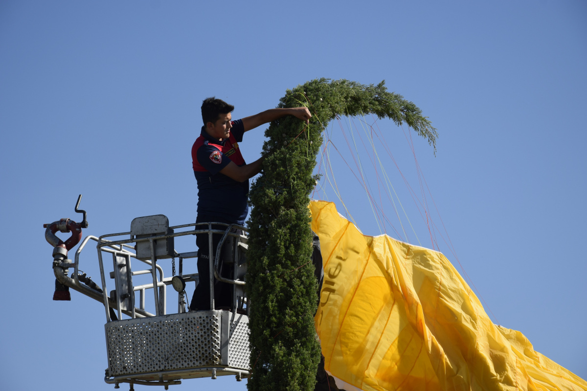 Yer çalışması yapan paraşütçü rüzgar çıkınca çam ağacına takıldı