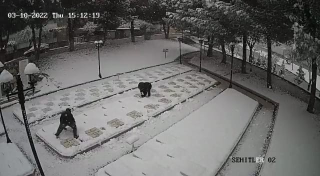 Çanakkale’de 2 çocuk karla kaplanan şehitlikteki mezar taşlarını temizledi