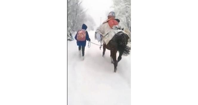 Kar yolu kapatınca çocukları at sırtında okula götürdü