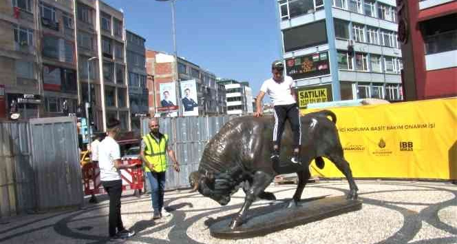 Kadıköy’de, bakıma alınan Boğa Heykeli’nin üzerine çıkıp fotoğraf çektirdi