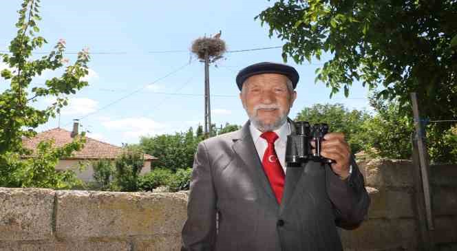 Gözlerindeki bozukluk engel olmadı, direkteki leyleklere dürbünle bakıyor