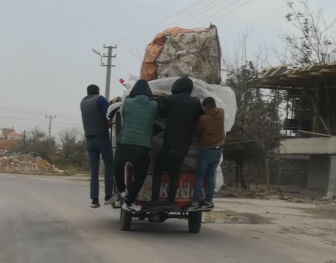 Şiddetli r&uuml;zgarda triport&ouml;r devrilmesin diye &uuml;zerine binip gittiler
