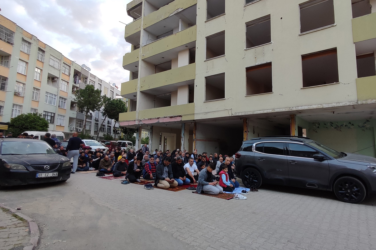 Bayram namazını yıkılması için boşaltılan orta hasarlı binanın altında kıldılar
