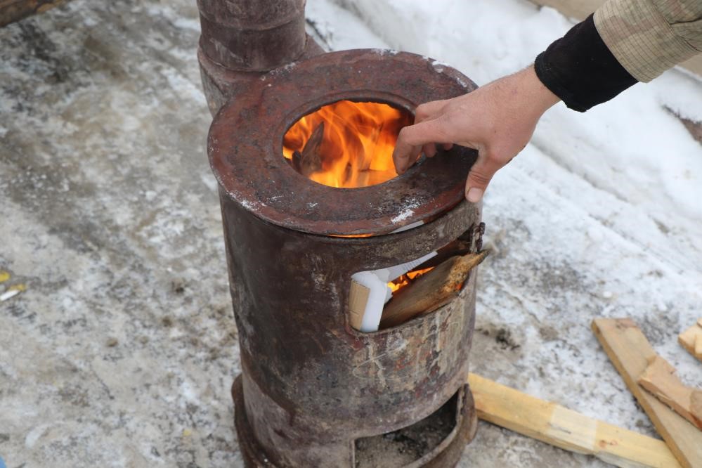 Doğu buz kesti, pazarcılar soğuktan korunmak i&ccedil;in soba kurdu
