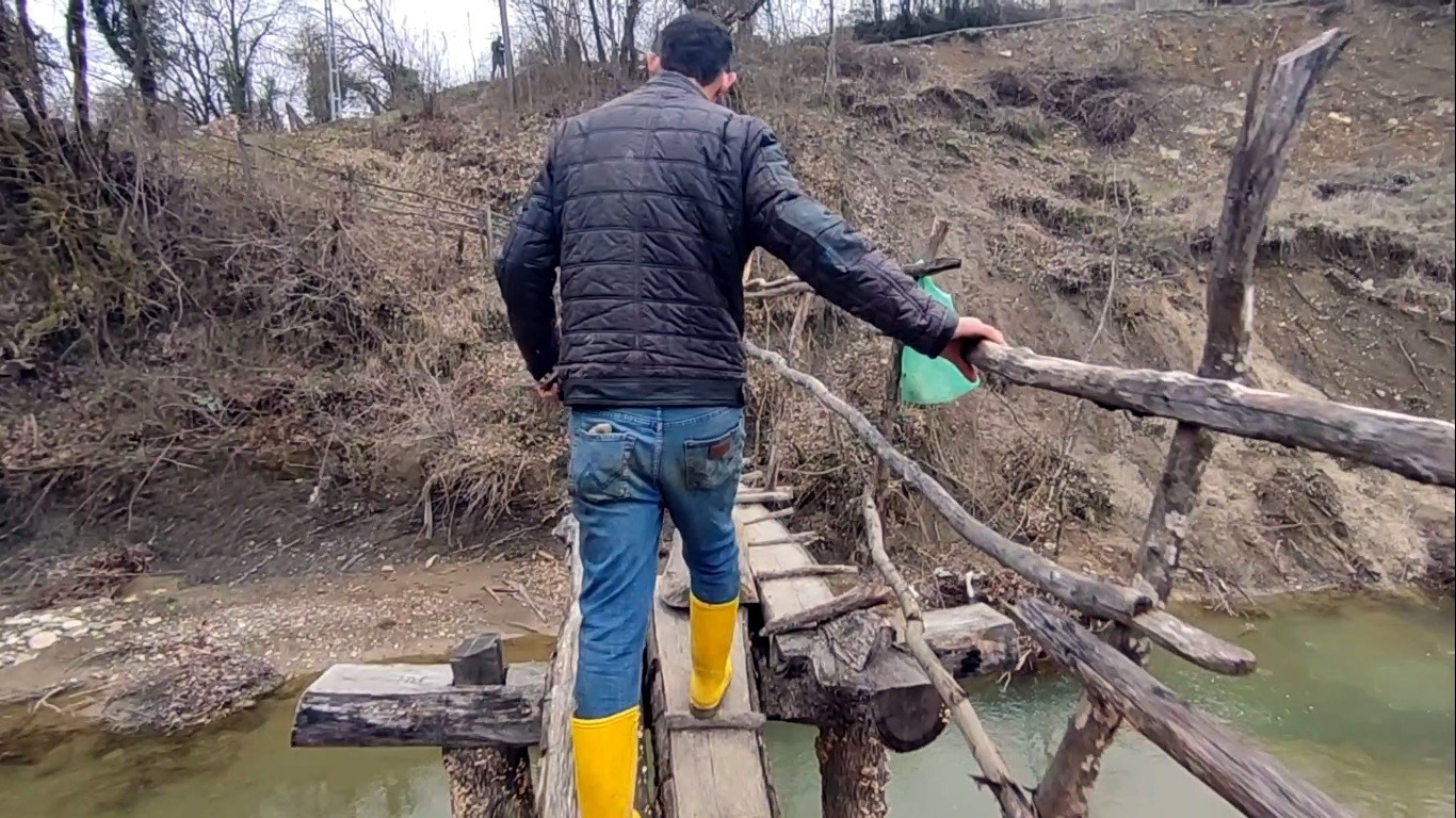 Evlerine ulaşmanın tek yolu derme çatma köprü
