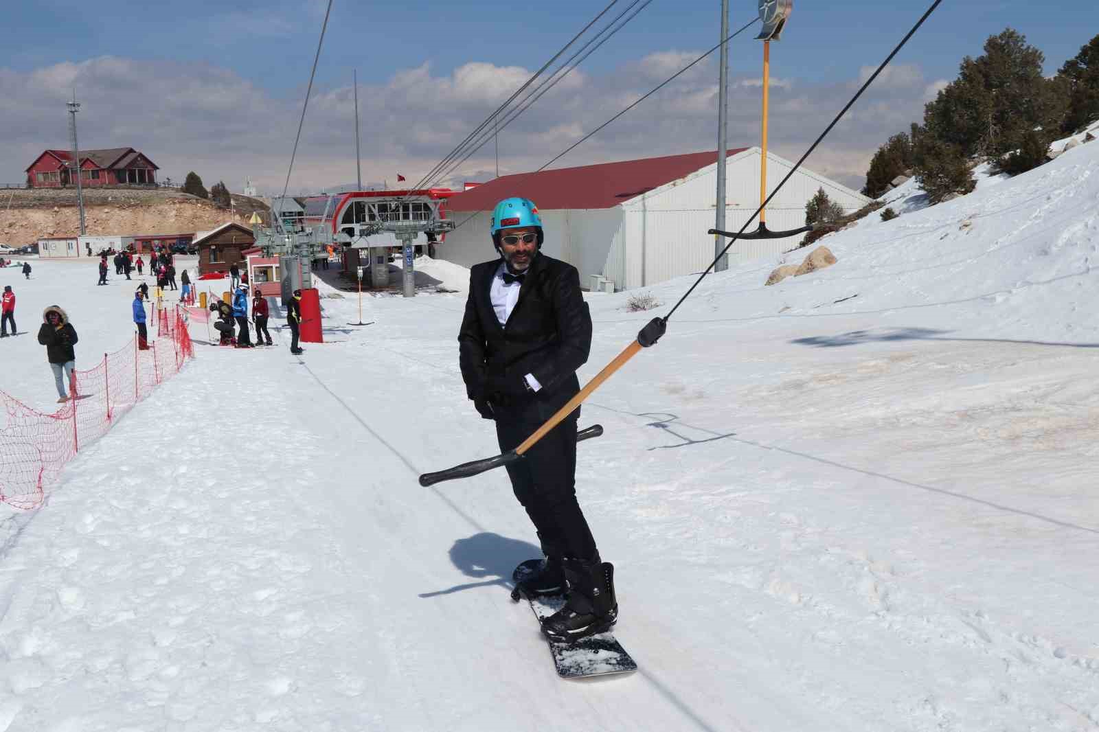 Kayak sezonunu takım elbiseyle snowboard yaparak uğurladılar
