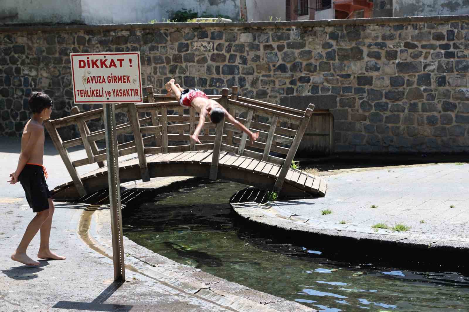 Diyarbakır’da hava sıcaklığının birden yükselmesiyle çocuklar süs havuzuna girdi

