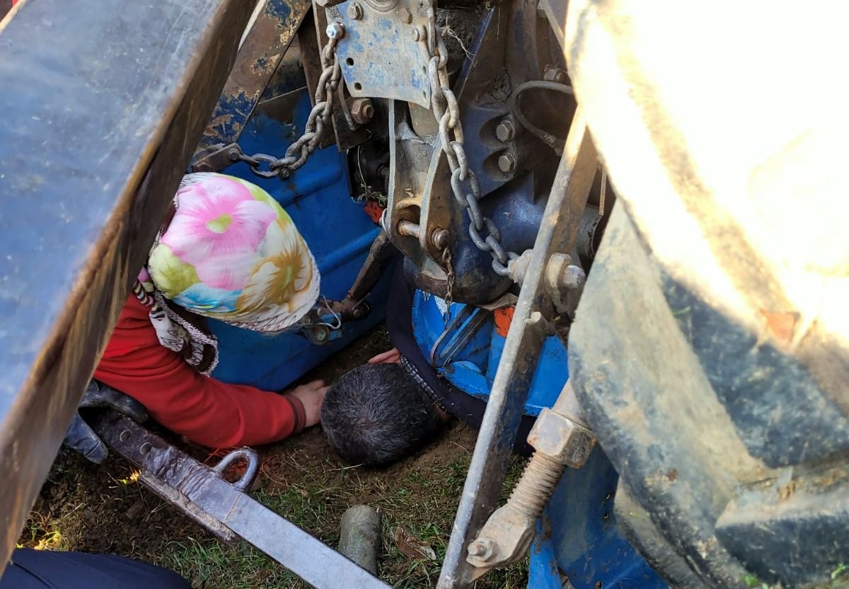 Devrilen traktörün altında kalan sürücü yaralandı