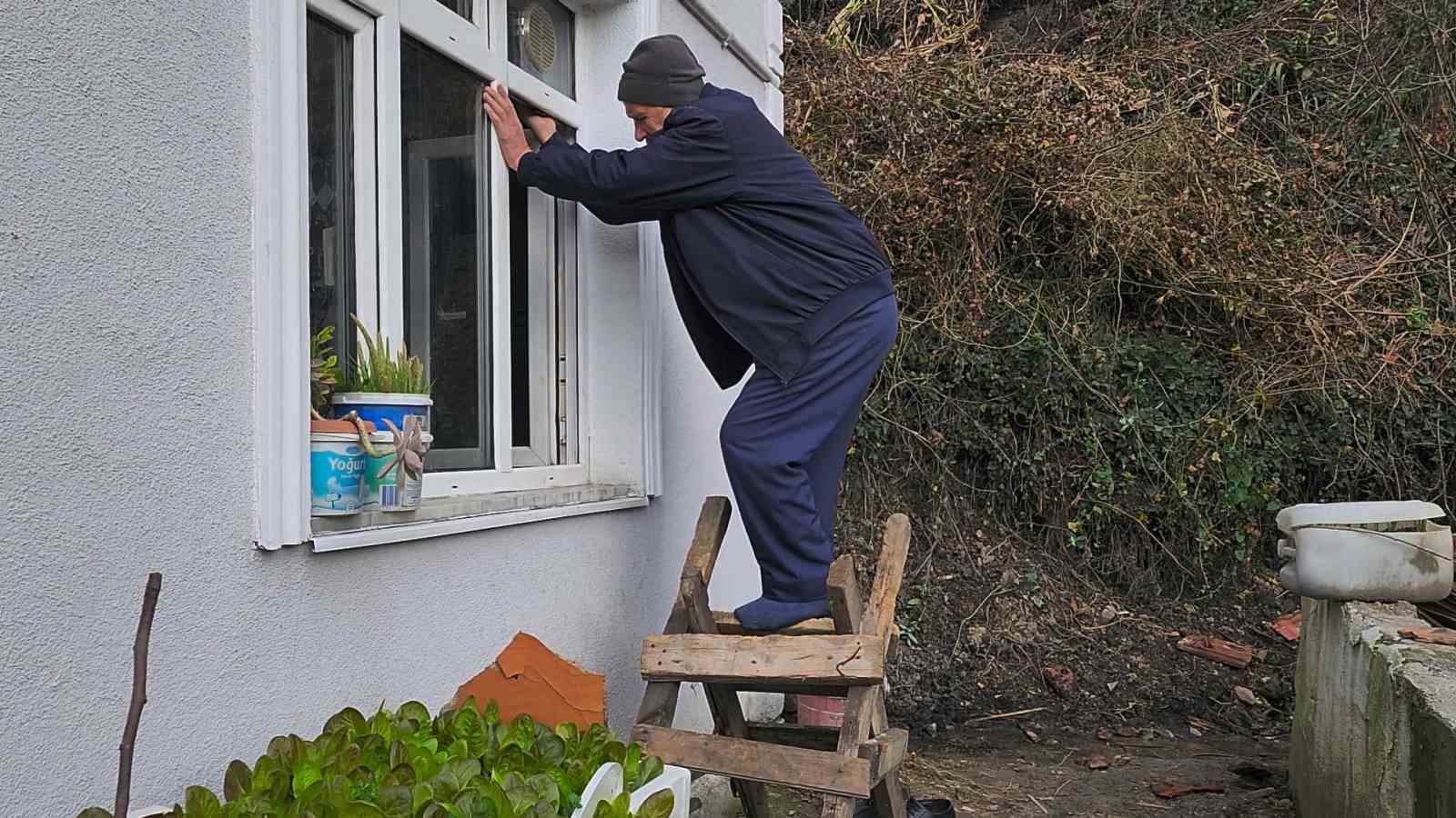 Yaşlı çift, heyelan nedeniyle girişi kapanan evlerine pencereden giriyor
