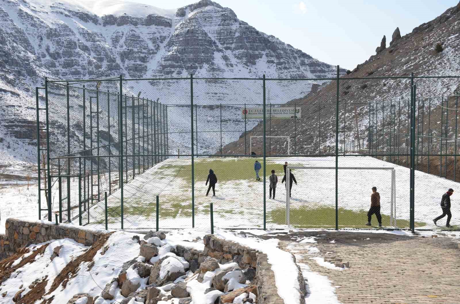 Şırnak’ta çocuklar futbol aşkına karlı yolları aşıp halı sahada top oynuyor