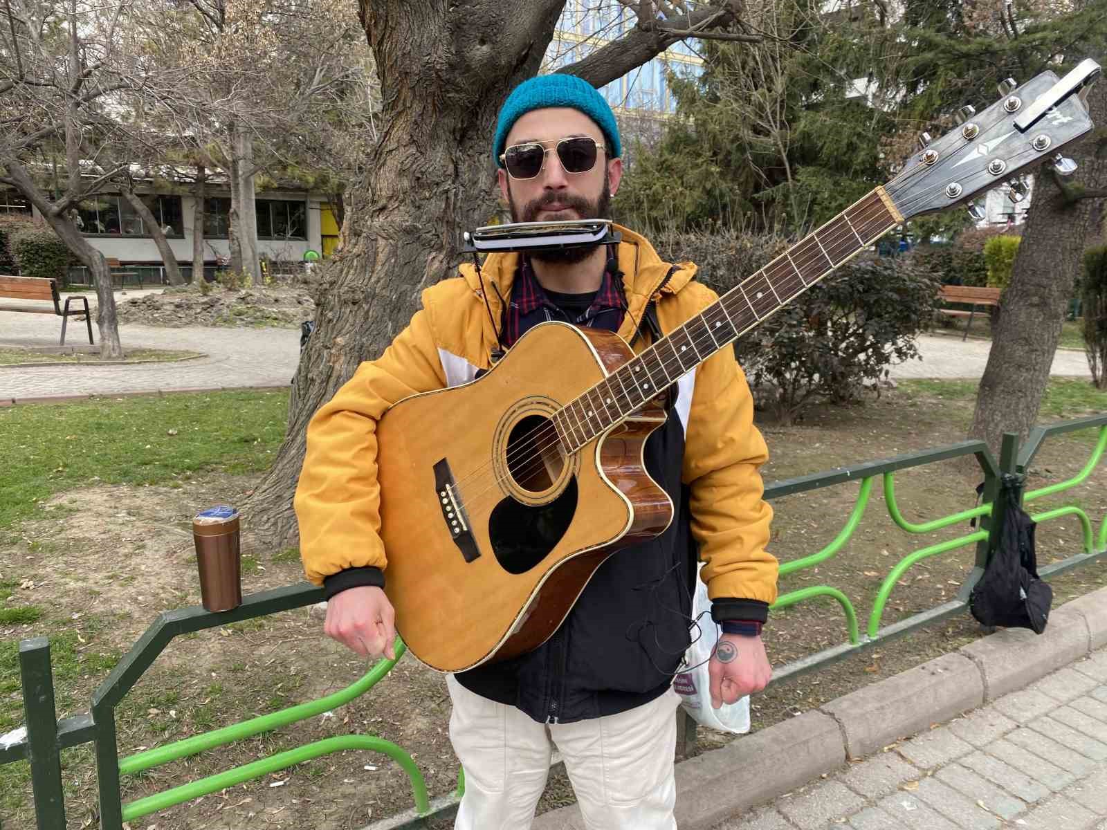 Aynı anda hem mızıka hem de gitar çalıyor
